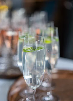 Elegante Gläser mit sprudelndem Wasser und frischen Limetten, die in einem festlichen Ambiente präsentiert werden.